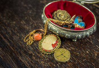 Small jewel case with beautiful old style jewellery with old wooden table as a background
