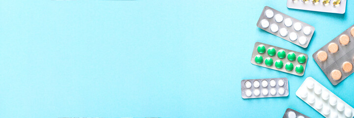 Pills on blue background top view. 