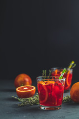 Red orange juice in a large glass or blood orange sparkling vodka cocktail or aperitif with campari