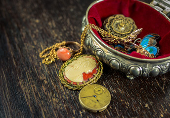 Small jewel case with beautiful old style jewellery with old wooden table as a background