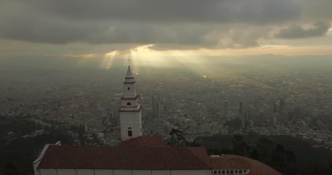 Sunset aerial flying over Monserrate Church in Bogota Colombia with the city below	bogota, colombia, monserrate, landmark, capital, colombia, church, religion, powerful, moving, beauty, city, architec