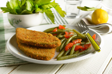 vegetarian cutlet with green beans and tomato garnish