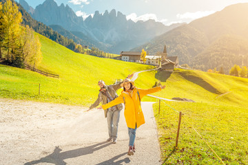Active three friends travel during autumn holiday and vacation in the mountains of the Dolomites in...