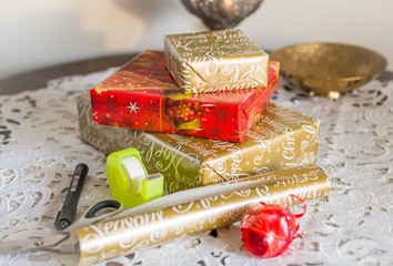 Packing Christmas gifts using scissors, paper, tape and ribbons.