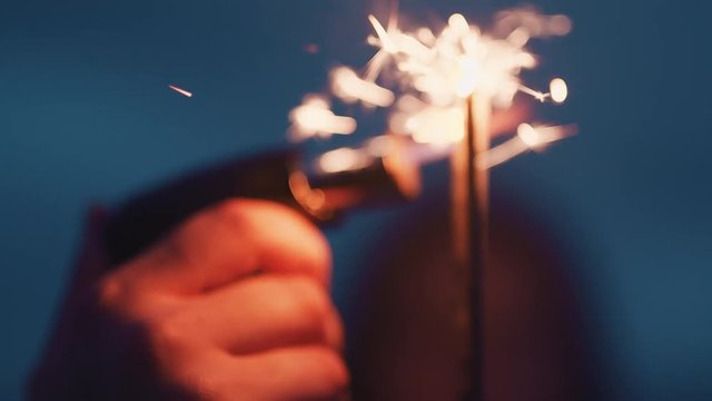 Close Up Hand Lighting Sparkler Celebrating New Years Eve On Beach At Night Watching Beautiful Sparks