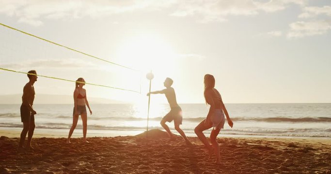 Friends playing beach volleyball at sunset, slowmotion cinematic summer lifestyle