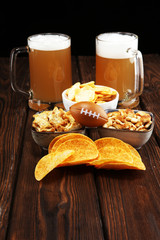 Chips, salty snacks, football and Beer on a table. Great for Bowl Game projects.