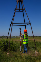 .Professional Female Land Surveyor with Theodolite..Surveyor Engineer Working with Theodolite on a Green Field. Women in Profession Concept