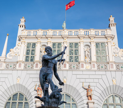 Gdansk, Poland, old town, Statue of Neptune, symbol of Gdansk, with Artus Court in the back and city flag of Gdansk on top.