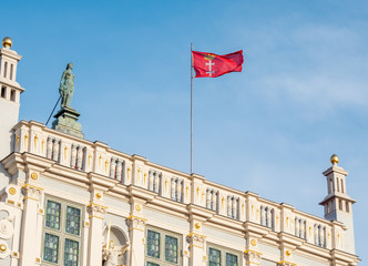Fototapeta na wymiar Gdansk, Poland, city flag, sign of Gdansk, on top of old building - Artus Court.