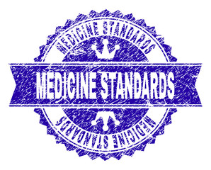Obraz premium MEDICINE STANDARDS rosette stamp seal imitation with grunge texture. Designed with round rosette, ribbon and small crowns. Blue vector rubber print of MEDICINE STANDARDS title with dirty texture.