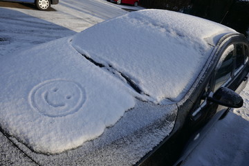 Hey ! Hello winter ! Snow, ice and a funny smiley on the  hood of a car