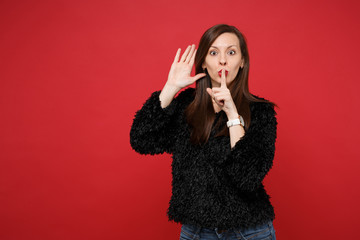 Young woman saying hush be quiet with finger on lips shhh gesture, eavesdrop hearing with hand near...