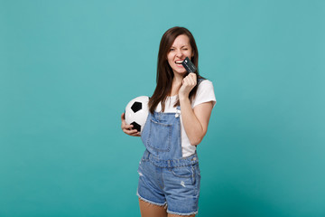 Funny pretty blinking young woman football fan support favorite team with soccer ball, credit bank card isolated on blue turquoise background. People emotions, sport family leisure lifestyle concept.