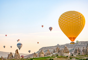 Fototapeta na wymiar Colorful hot air balloons flying over rock landscape at Cappadocia Turkey