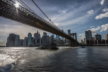Fototapeta na wymiar Cargo ship under Brooklyn Bridge.