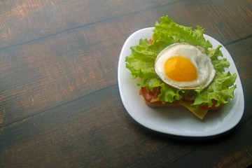 Preparing a sandwich with scrambled eggs, bacon and cheese