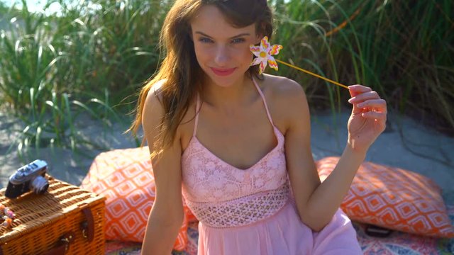 Portrait of happy Caucasian American woman relaxing with picnic on ocean beach