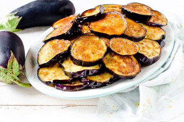Fried eggplant on a plate on a wooden table