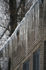 icicles hanging from the roof of a brick house