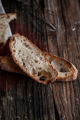 Fresh bread slice and cutting knife on rustic table