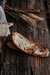 Fresh bread slice and cutting knife on rustic table