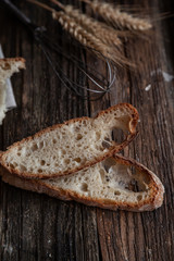 Fresh bread slice and cutting knife on rustic table