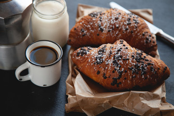 Croissant with chocolate and coffee on the wooden table