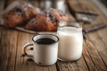 Croissant with chocolate and coffee on the wooden table