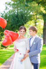Happy newlyweds hug each other on the background of beautiful nature