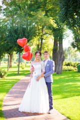 Happy newlyweds with red balloons