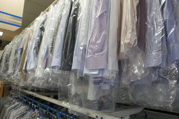 Freshly cleaned men's shirts and ladies blouses
in a textile cleaning, hanging on hangers and packed in plastic wrap
