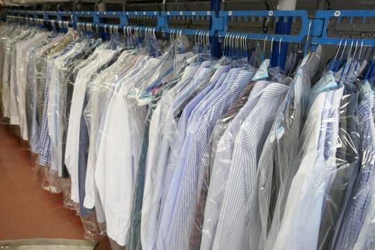 Freshly cleaned men's shirts and ladies blouses
in a textile cleaning, hanging on hangers and packed in plastic wrap

