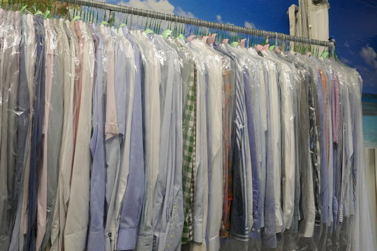 Freshly cleaned men's shirts and ladies blouses
in a textile cleaning, hanging on hangers and packed in plastic wrap

