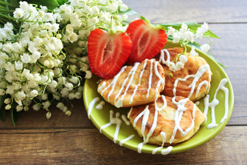 Spring bouquet lily of the valley, Cheesecakes with strawberries. Breakfast of cottage cheese cheesecakes. Spring breakfast.