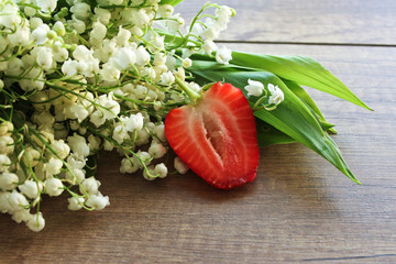 Spring bouquet of lilies of the valley, Lily of the valley on a wooden background. Strawberry
