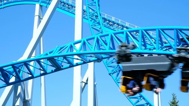 Rollercoaster upside down close-up in an amusement park, slow motion