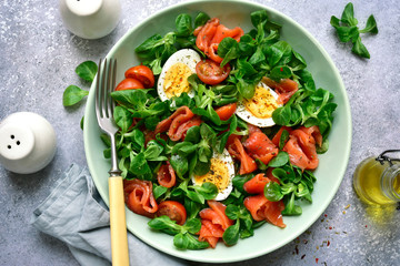 Green salad with salted salmon, tomato and boiled eggs.Top view with copy space.