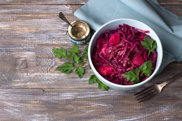 Stewed red cabbage with apples, spices and greens on a wooden background, free space. delicious homemade healthy food