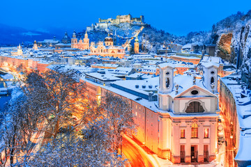 Salzburg, Austria: Winter view of the historic city of Salzburg with famous Festung Hohensalzburg and Salzach river illuminated in beautiful twilight during scenic Christmas time in winte