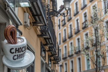 View of a giant cup announcing chocolate with churros in a typical street of Madrid