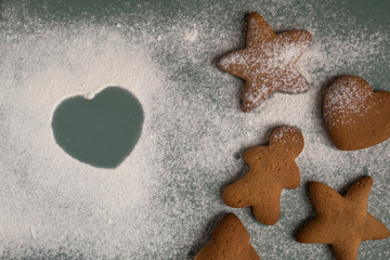 Obraz na płótnie Canvas Cooking gingerbread cookies from dough using different forms - heart, star, Christmas tree, men. Home baking. Love concept.