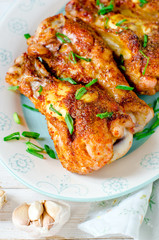Baked chicken legs on a plate on a white wooden table