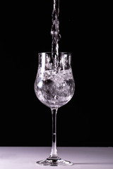 Close up view of splushing water in glass isolated. Black and white. Beautiful backgrounds.