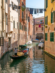 Fototapeta na wymiar Gondel fahren durch die engen Kanäle in Venedig