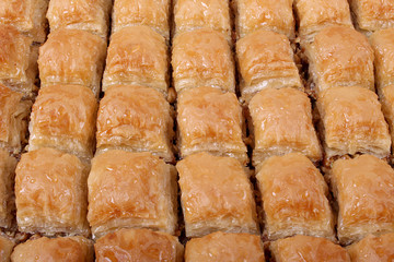 Baklava with walnut with a large table tray and a white striped from a close angle