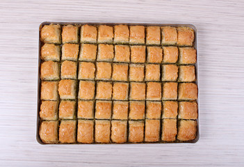 Baklava with walnut with a large table tray and a white striped from the bottom