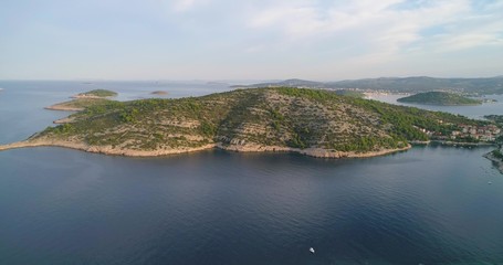 Croatian islands, C4k aerial, drone shot, towards a hill on a green, island, in the adriatic, turquoise sea, on a sunny, summer morning, in Croatia