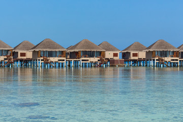 Water villas on a tropical resort island with turquoise water on a sunny day, Kaafu Atoll, Maldives, Indian Ocean