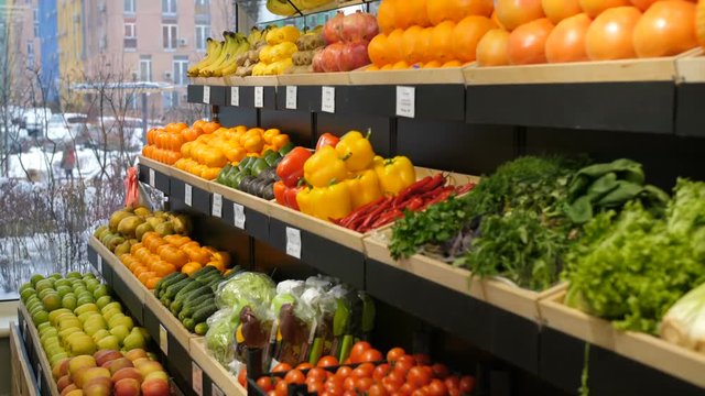 Abundance of fresh healthy organic fruits and vegetables on shelf at grocery store. Variety of eco-friendly ripe products on shop shelves in fruit and vegetable department of supermarket.